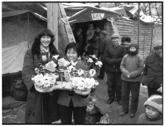 陕西华县农村里，结婚时新娘姥姥家送来祝贺的双虎头龙身鱼尾大面花。图为作者之一杨阳手捧面花。