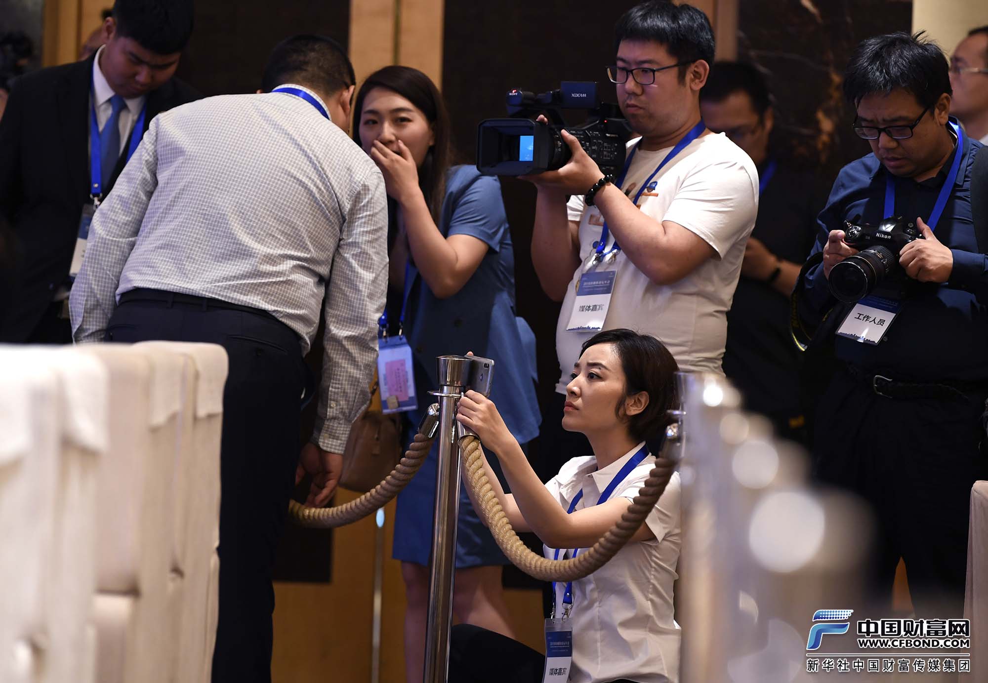 中国财富网记者张静静在金融街论坛年会现场手机采访拍摄